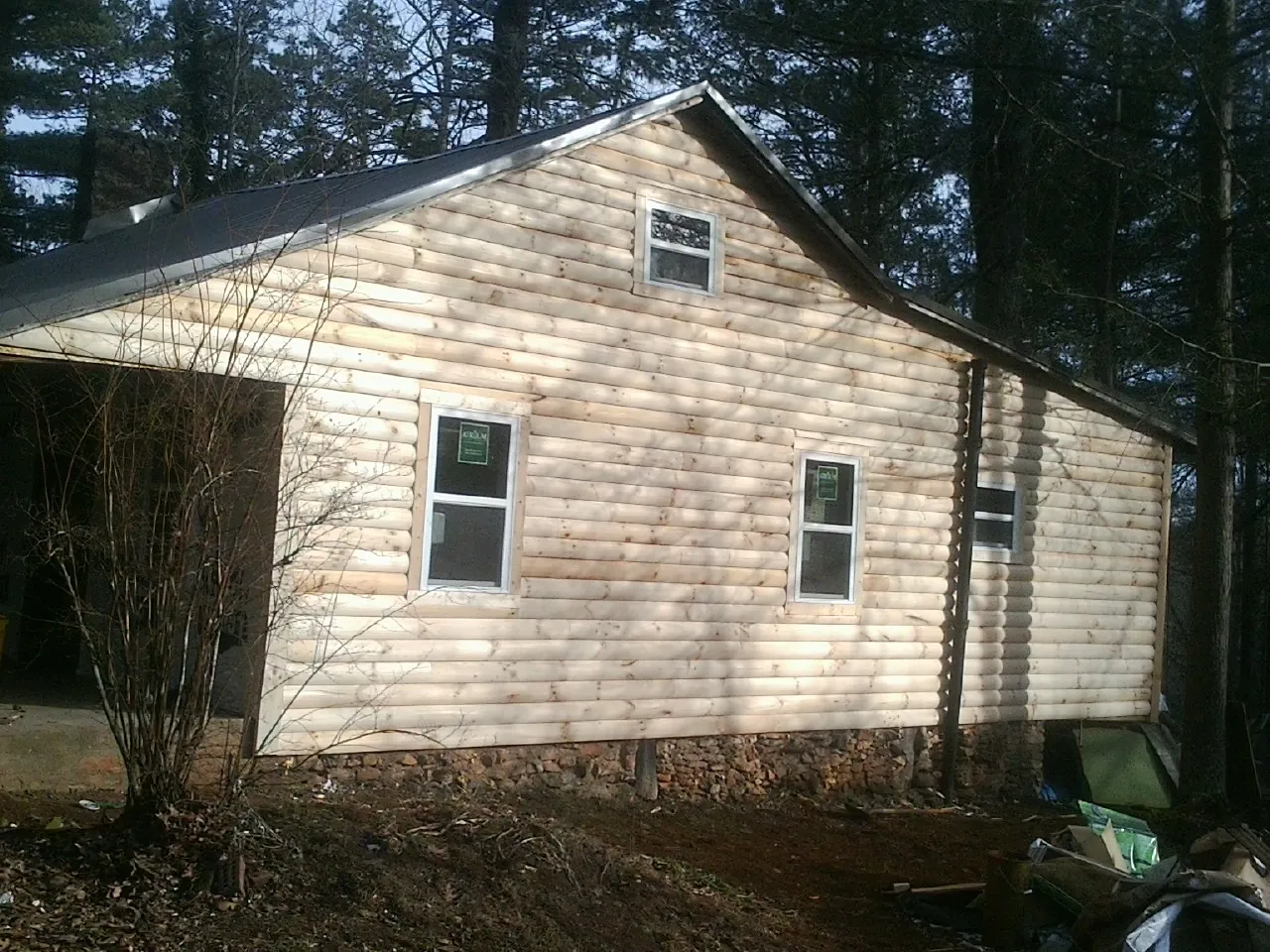 New log siding and dark metal roofing on a gable end in Porterville