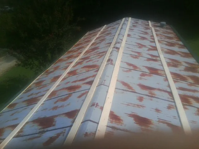 Rusted metal roof panels with new wood purlins before replacement — Storm Damage Roof Repair in Porterville by Roofing Brothers