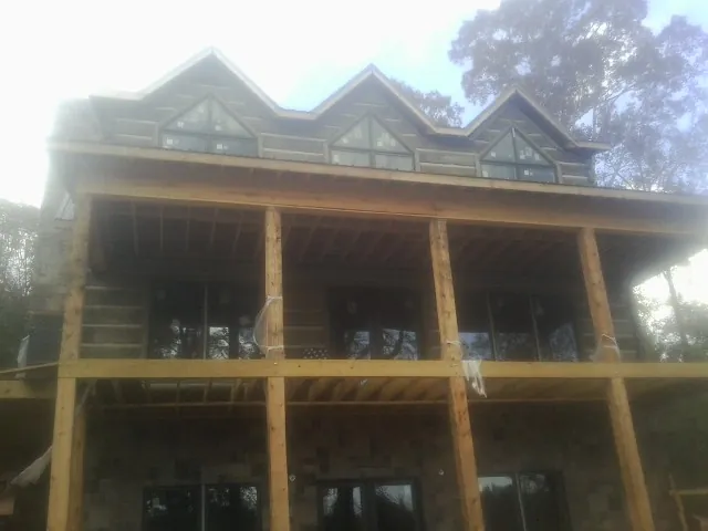 Dormers and porch framing on a large log home under construction — Roof Coating work by our crew in Porterville