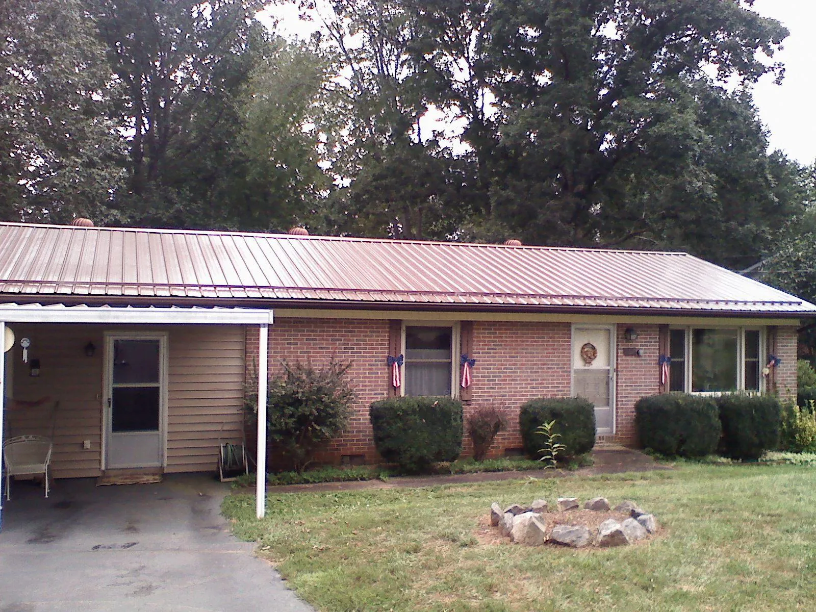 Bronze metal roof and carport on a brick ranch home — Roof Repair work by our crew in Porterville