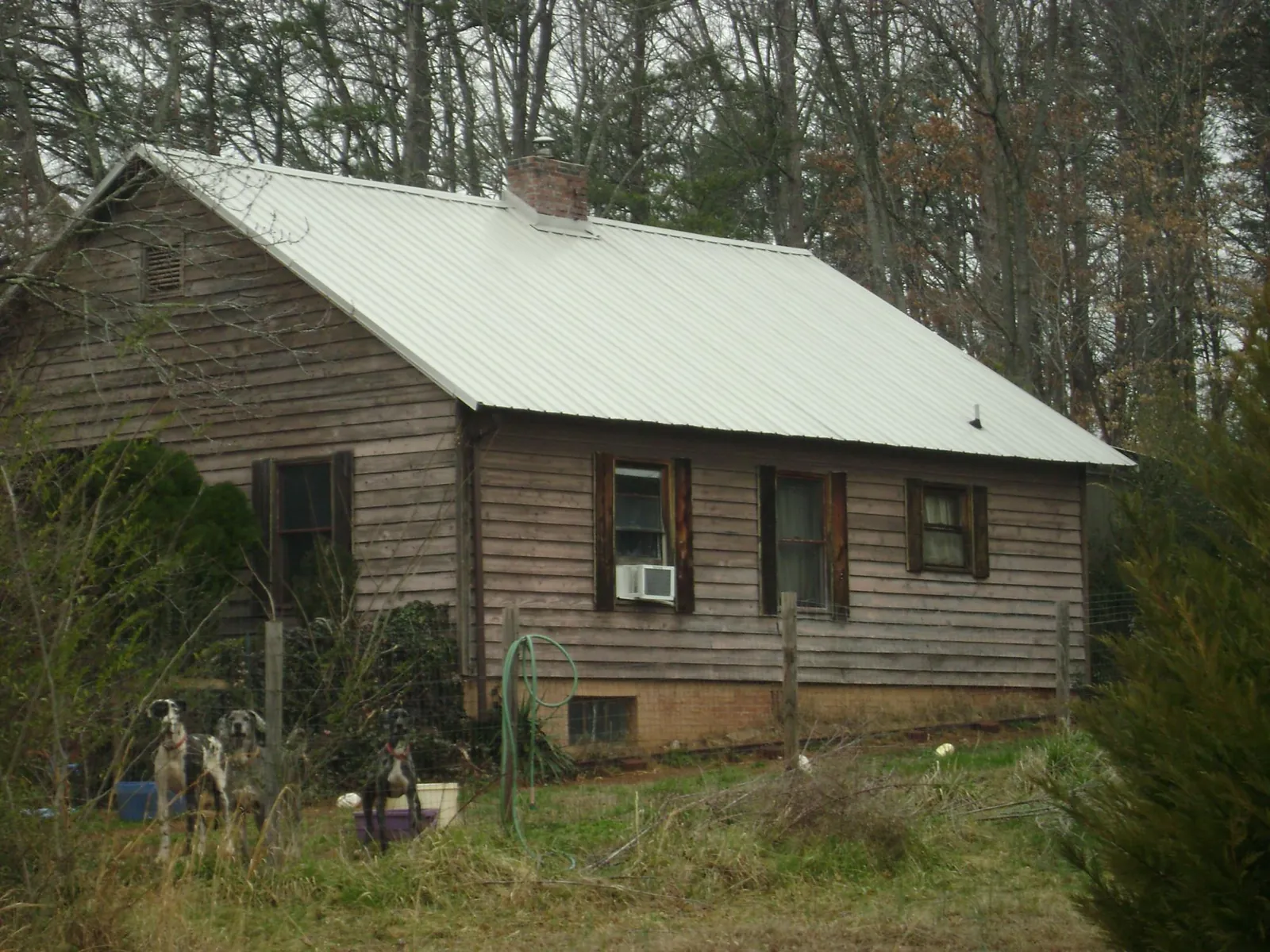 White metal roof on an old wood sided farmhouse, from a Metal Roof Installation job in Porterville